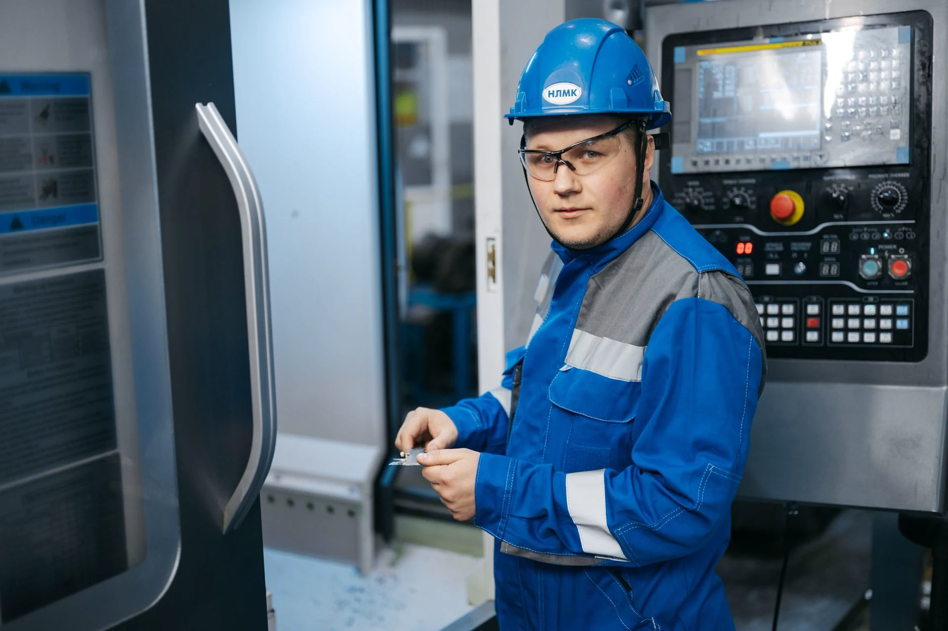 Technician at a CNC machine; contextual stock photograph