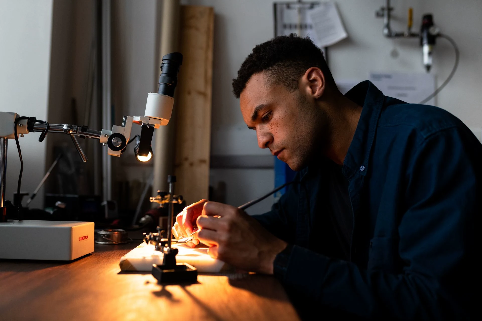 Engineer working on electronics at a workshop bench; contextual stock photograph